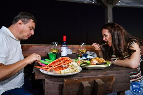 9月2日，食客們在俄羅斯符拉迪沃斯托克的一家餐館品嘗帝王蟹。新華社記者 曹陽 攝