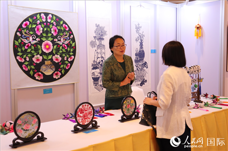 青海非遺文化傳承人向嘉賓介紹展品。人民網(wǎng)實(shí)習(xí)生姚欣可攝