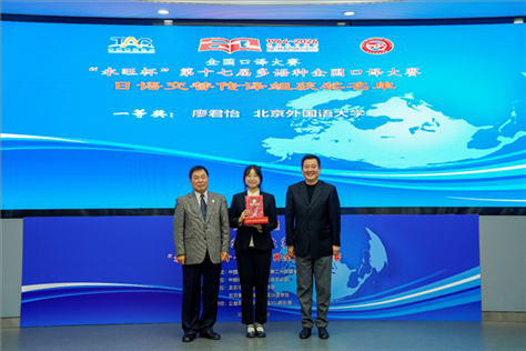 中國翻譯協(xié)會副會長中國外文局中東歐與中南亞傳播中心（人民畫報社）主任姜永鋼（右一）、原中國教育工會全國委員會巡視員白立文（左一）為獲得日語交傳組一等獎的北京外國語大學廖君怡頒獎（主辦方提供）