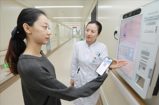 醫(yī)護(hù)人員引導(dǎo)患者在自助機(jī)前辦理自助入院手續(xù)。圖片來源：山東第一醫(yī)科大學(xué)第二附屬醫(yī)院