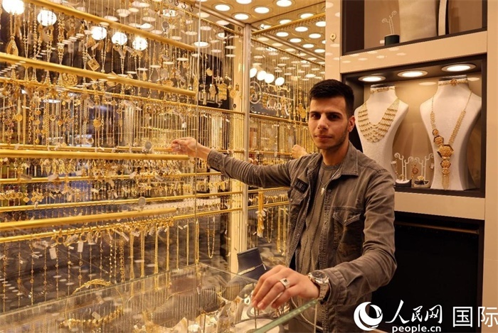 一名銷售員展示黃金飾品。人民網(wǎng) 伊納斯·易卜拉欣攝