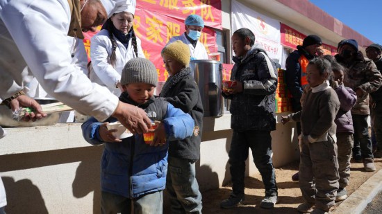 1月14日，廚師們正在給前來用餐的小朋友們打飯。新華社記者 邱星翔 攝