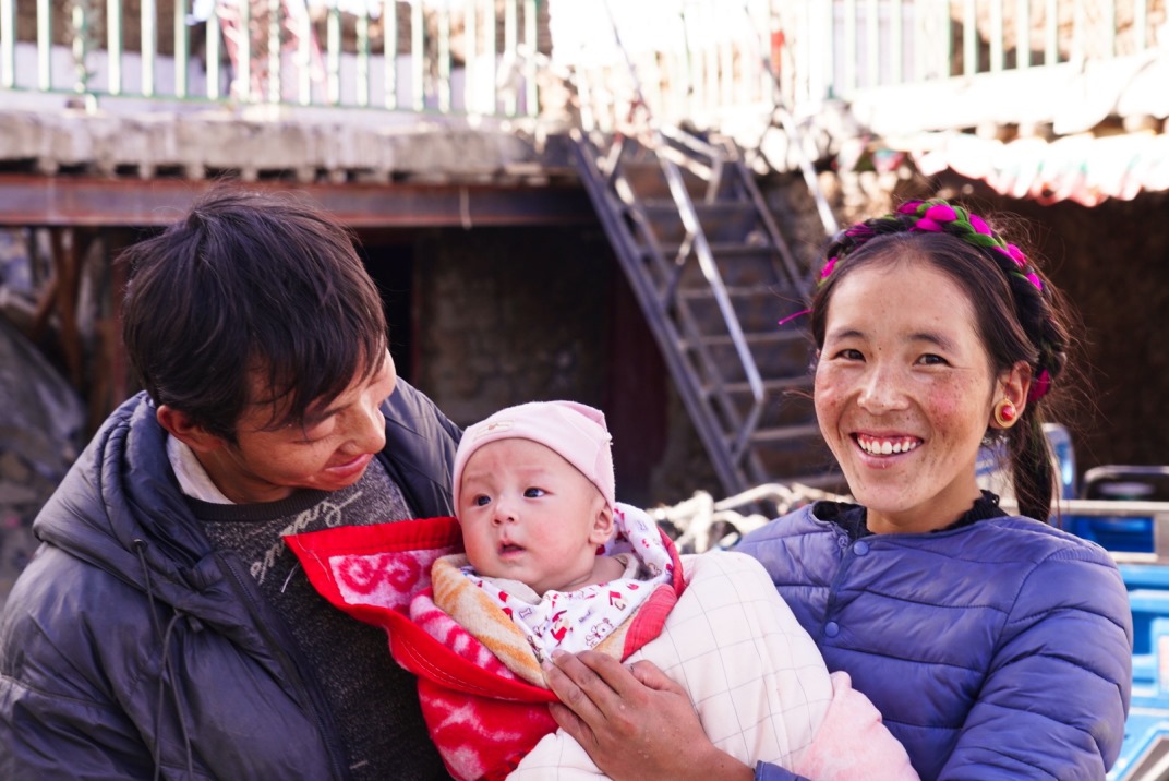 1月11日，在西藏日喀則市人民醫(yī)院，受災(zāi)群眾抱著自己在地震中受傷的孩子康復(fù)出院。人民日報記者徐馭堯攝