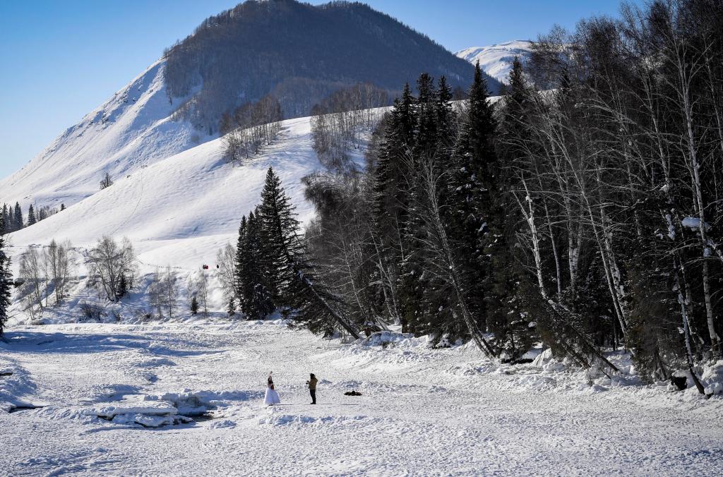 2024年2月5日，兩名游客在新疆阿勒泰地區(qū)布爾津縣禾木村拍照。新華社記者 馬鍇 攝