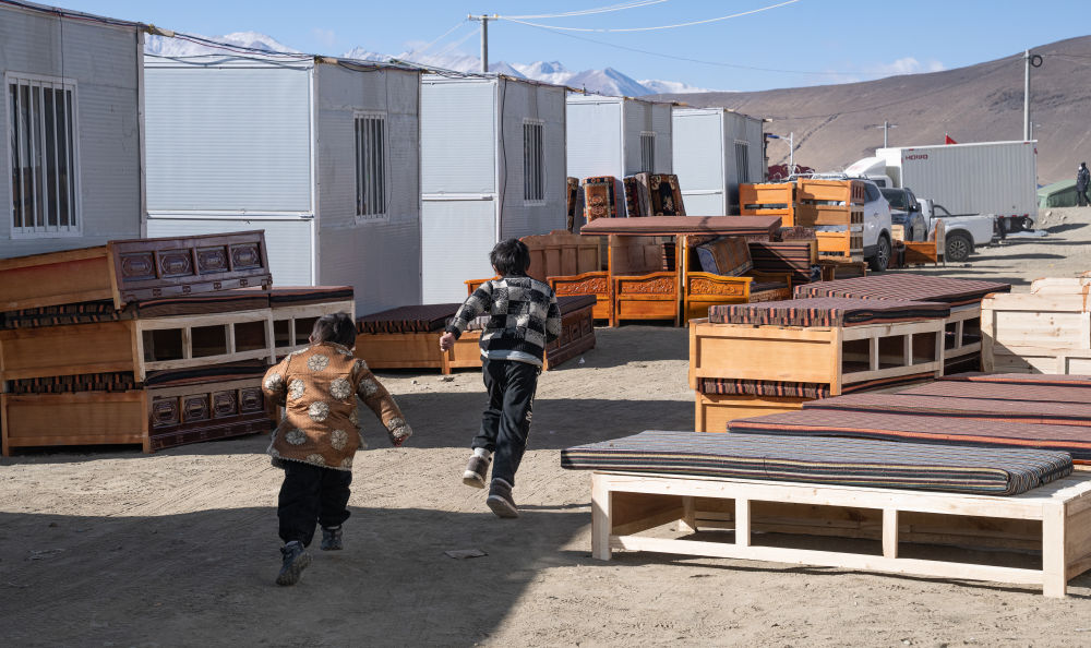 2025年1月13日，在定日縣嘎旦村，兩個孩子在剛運來的兩排藏床間奔跑。新華社記者丁增尼達 攝