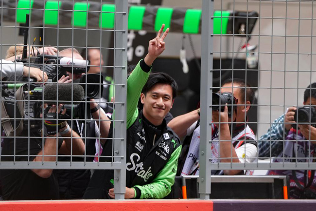 2024年4月19日，索伯車隊(duì)中國(guó)車手周冠宇（中）在練習(xí)賽前向觀眾致意。當(dāng)日，F(xiàn)1中國(guó)大獎(jiǎng)賽在上海開(kāi)賽。中國(guó)車手周冠宇主場(chǎng)首秀參賽。新華社記者 夏一方攝