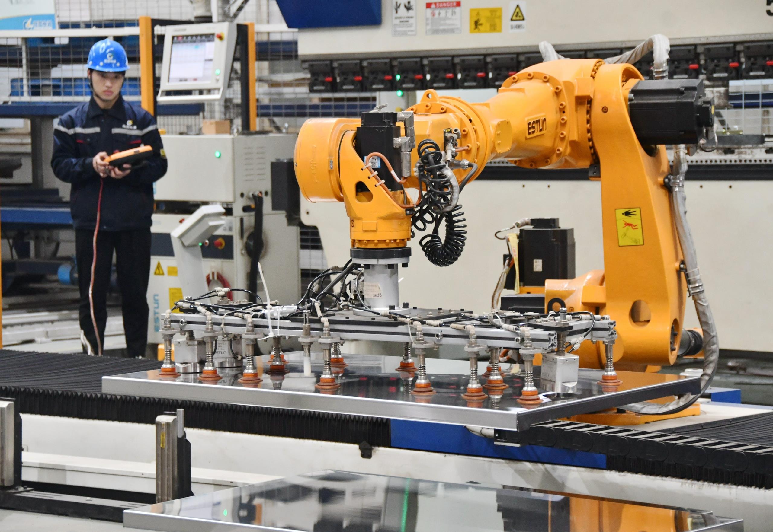 △2025年2月21日，河北邯鄲永年區(qū)工業(yè)園區(qū)的一家企業(yè)，工人正在操控工業(yè)機(jī)器人作業(yè)。