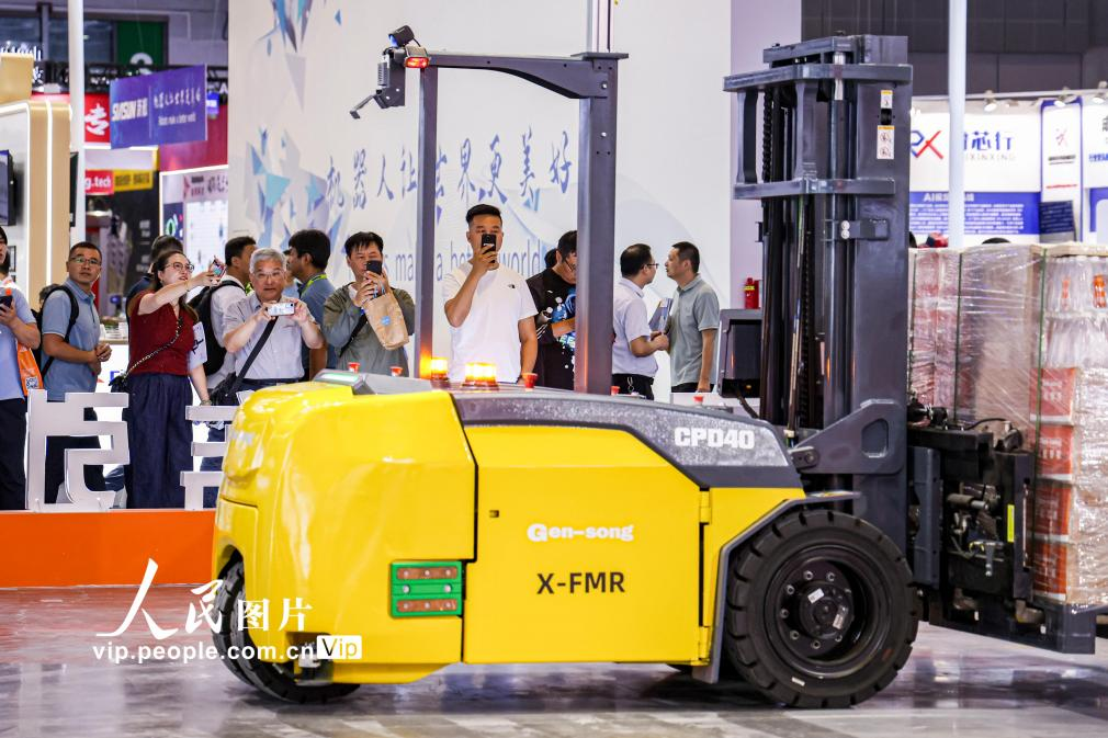 第24屆中國(guó)工博會(huì)現(xiàn)場(chǎng)，觀眾觀看叉取機(jī)器人作業(yè)演示。王初攝（人民圖片網(wǎng)）
