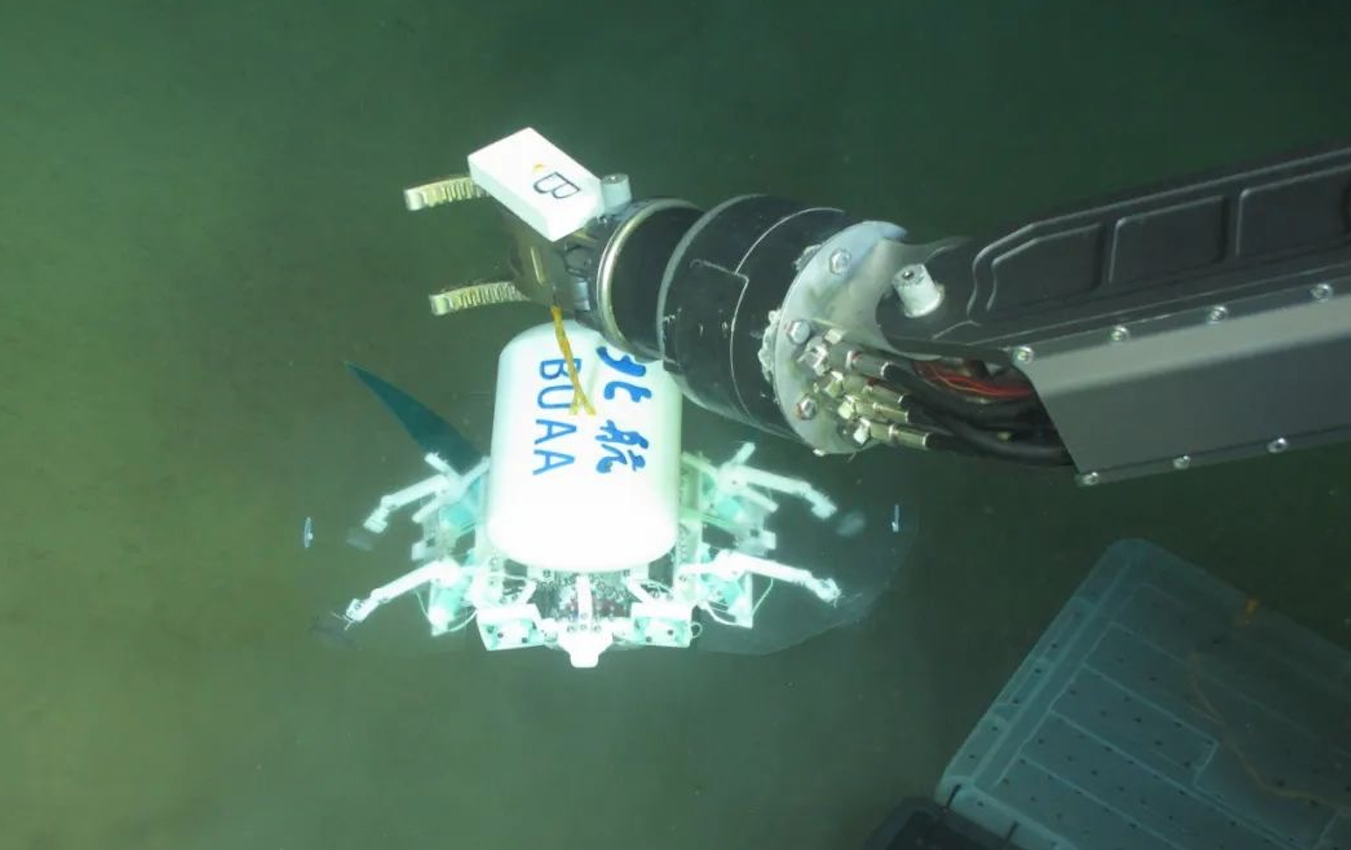 科研人員利用機(jī)械臂將北航深海小型機(jī)器人投于馬里亞納海溝。校方供圖