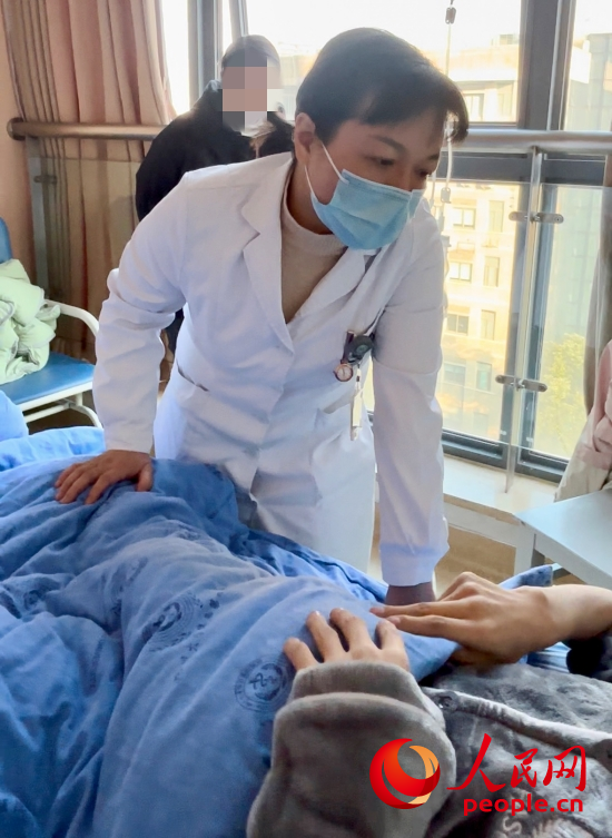 鄧茜查房時詢問患者情況。人民網(wǎng)記者 金慧慧攝