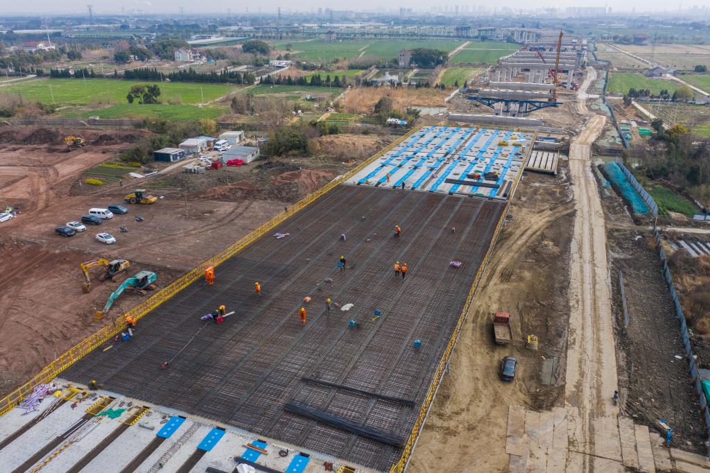 3月7日，在524國(guó)道秀洲王江涇至新塍公路工程TJ02標(biāo)段，作業(yè)人員正在進(jìn)行60米鋼混組合梁現(xiàn)澆橋面板鋼筋焊接及綁扎作業(yè)（無(wú)人機(jī)照片）。新華社記者 徐昱 攝