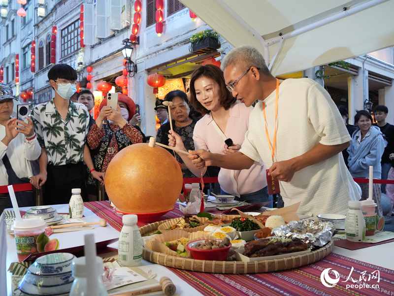 嘉賓品嘗海南傳統(tǒng)美食“煎堆”。人民網(wǎng)記者 張力洋攝