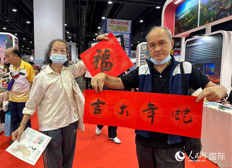 2025蛇年春節(jié)，泰國市民展示他們領(lǐng)到的華人手寫春聯(lián)。人民網(wǎng)記者 簡承淵攝