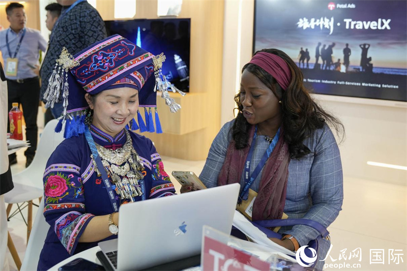 來自廣西的旅游業(yè)者同客戶交流。人民網(wǎng)塔里克·易卜拉欣攝
