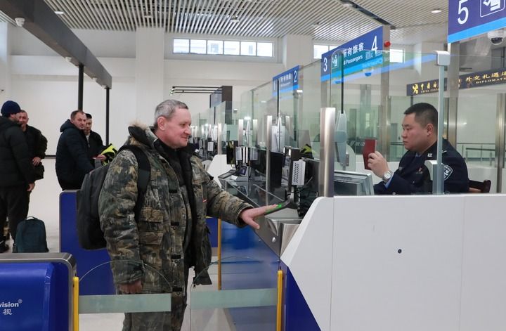 2024年12月10日，在黑河公路口岸旅檢大廳，黑河出入境邊防檢查站民警為首班次客車入境旅客辦理邊檢通關(guān)手續(xù)。當(dāng)日，中國黑河公路口岸—俄羅斯卡尼庫爾干公路口岸旅客運(yùn)輸正式開通。新華社發(fā)（劉松攝）