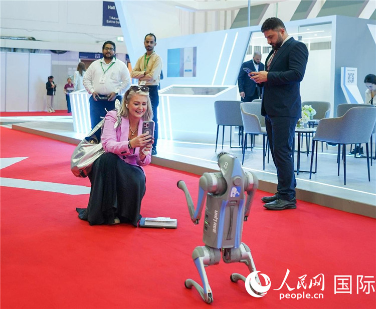 與會(huì)嘉賓被中企機(jī)器人吸引。人民網(wǎng) 塔里克·易卜拉欣攝