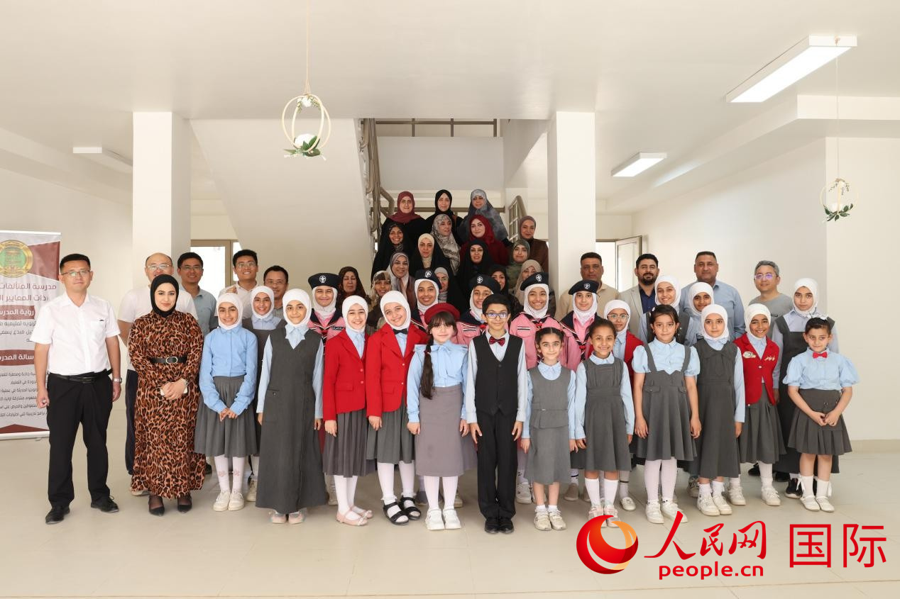中國電建員工與阿爾穆塔?阿里卡特國際學校的師生及政府官員等合影。人民網(wǎng)記者 薛丹攝