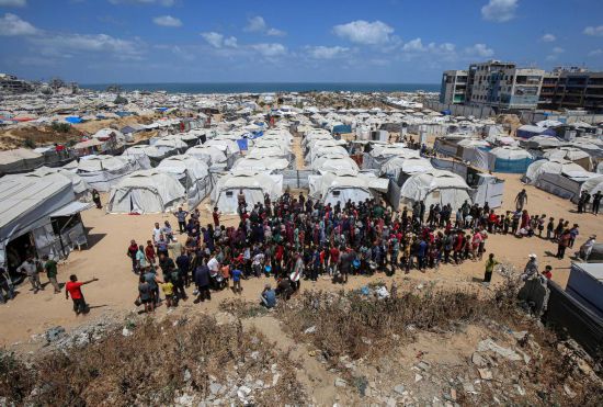 5月28日，人們?cè)诩由吵俏鞑康纳程犭y民營(yíng)等待領(lǐng)取救助食物。新華社發(fā)（里澤克·阿卜杜勒賈瓦德攝）