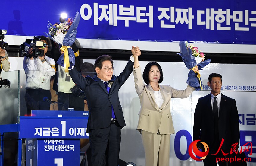 6月4日凌晨，確定當(dāng)選韓國(guó)總統(tǒng)的李在明舉手向歡呼的支持者們致意。 人民網(wǎng) 康炯彬攝