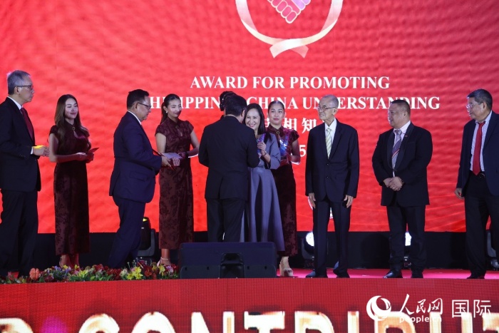 黃溪連大使給榮獲“重要貢獻(xiàn)獎”的奎松市市長喬伊·貝蒙蒂等人頒獎。人民網(wǎng)記者 樊帆攝