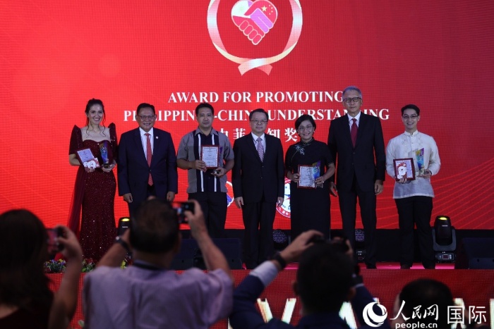 黃溪連大使和菲中了解協(xié)會主席與榮獲“友誼獎”的獲獎?wù)吆嫌傲裟?。人民網(wǎng)記者 樊帆攝